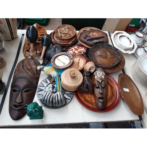 212 - A large collection of mostly treen ornaments to include decorative African tribal masks, dishes, pla... 