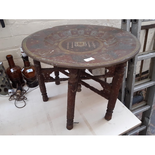 235 - A well detailed Middle Eastern brass travel table with etched Taj Mahal, peacock and floral design o... 