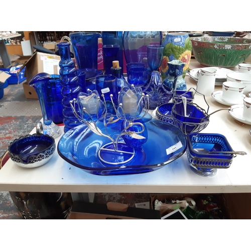 243 - A large collection of blue glassware to include vases, bowls, glasses etc.