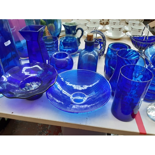 243 - A large collection of blue glassware to include vases, bowls, glasses etc.