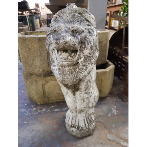 706 - A cast stone lion garden ornament - measuring approx. 20