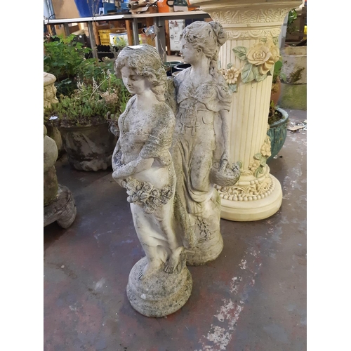 748 - Two cast stone classical lady statues - one measuring approx. 66cm and the other 69cm