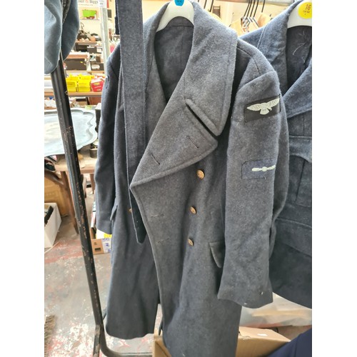 239 - A collection of 1950’s RAF uniform each bearing original arm patches to include a greatcoat dated 19... 