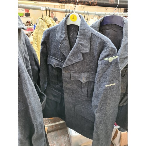 239 - A collection of 1950’s RAF uniform each bearing original arm patches to include a greatcoat dated 19... 