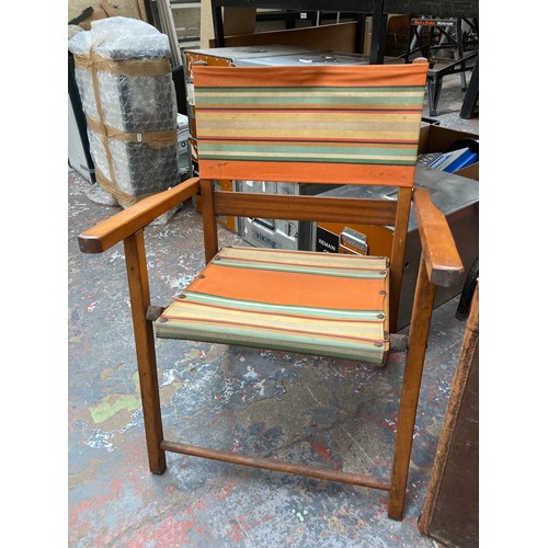 712 - A vintage beech and teak folding child's deck chair with striped upholstery - measuring approx. 64cm