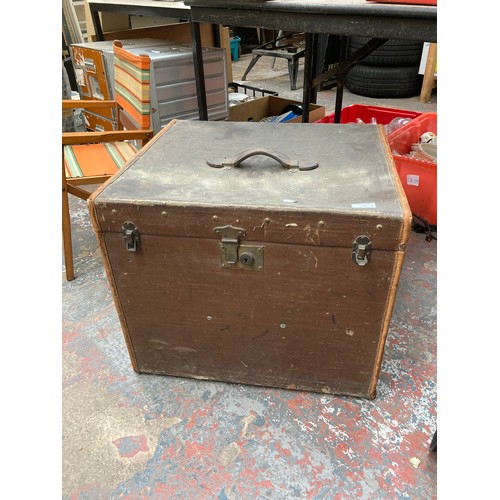 712A - A vintage brown canvas square travel trunk - measuring approx. 55cm in width, 48cm deep and 47cm in ... 