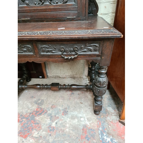 490 - A Victorian Jacobean revival oak bureau cabinet with fall front, key, two drawers and lower stretche... 