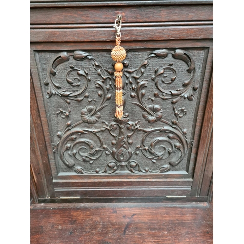 490 - A Victorian Jacobean revival oak bureau cabinet with fall front, key, two drawers and lower stretche... 