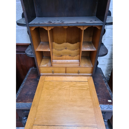 490 - A Victorian Jacobean revival oak bureau cabinet with fall front, key, two drawers and lower stretche... 