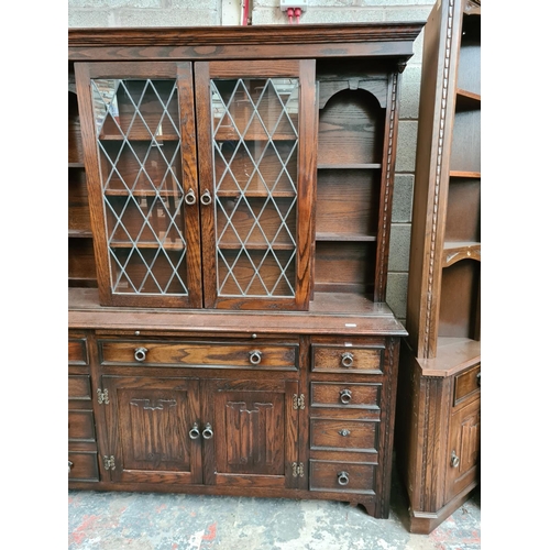 495 - A Jaycee oak dresser with two upper glazed doors, nine drawers and two lower cupboard doors - measur... 