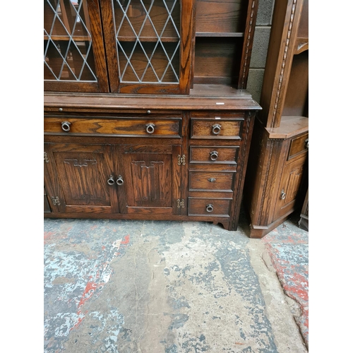 495 - A Jaycee oak dresser with two upper glazed doors, nine drawers and two lower cupboard doors - measur... 