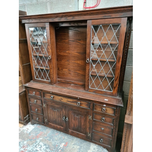 495 - A Jaycee oak dresser with two upper glazed doors, nine drawers and two lower cupboard doors - measur... 