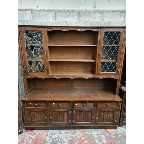 496 - A Jaycee oak dresser with two upper glazed doors, four drawers and four cupboard doors - measuring a... 