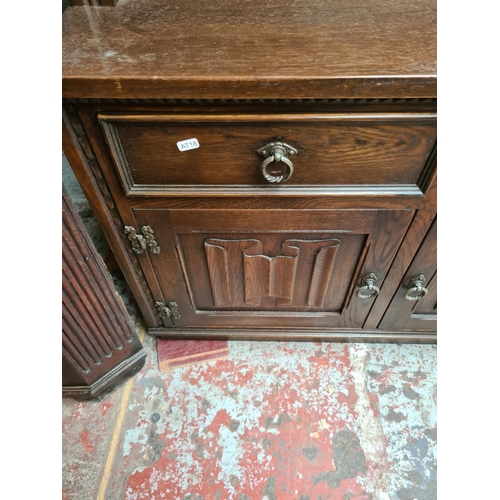 496 - A Jaycee oak dresser with two upper glazed doors, four drawers and four cupboard doors - measuring a... 