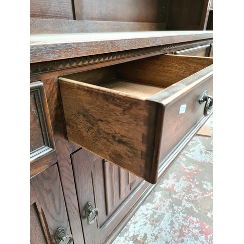 496 - A Jaycee oak dresser with two upper glazed doors, four drawers and four cupboard doors - measuring a... 