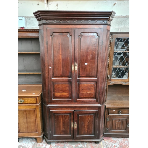 497 - A George III oak flat front corner cabinet with two upper doors, three internal shelves, two lower d... 