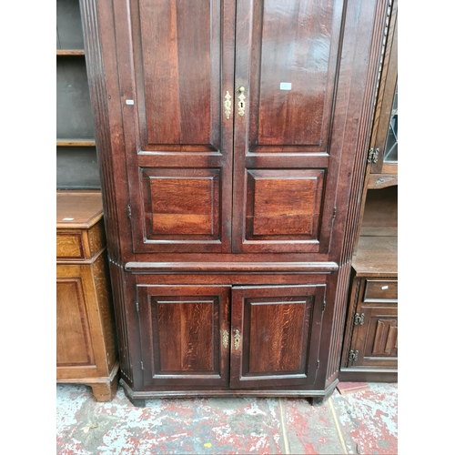 497 - A George III oak flat front corner cabinet with two upper doors, three internal shelves, two lower d... 