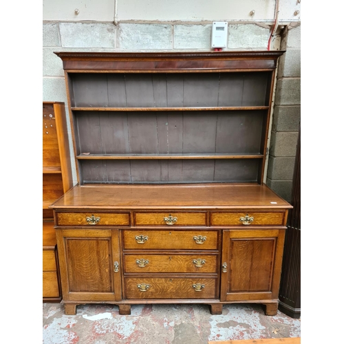 498 - A George III oak welsh dresser with upper plate rack, three upper drawers, two cupboard doors and th... 