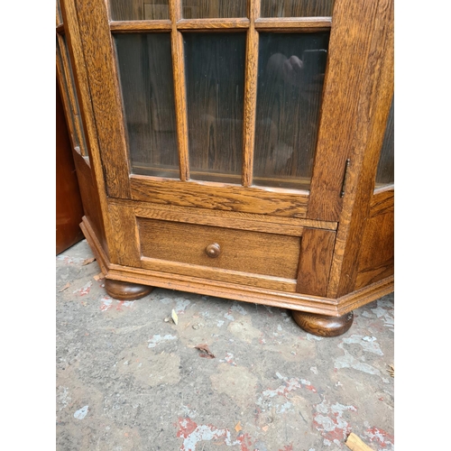 500 - An oak flat front display cabinet with one door, one drawer and key - measuring approx. 192cm high a... 