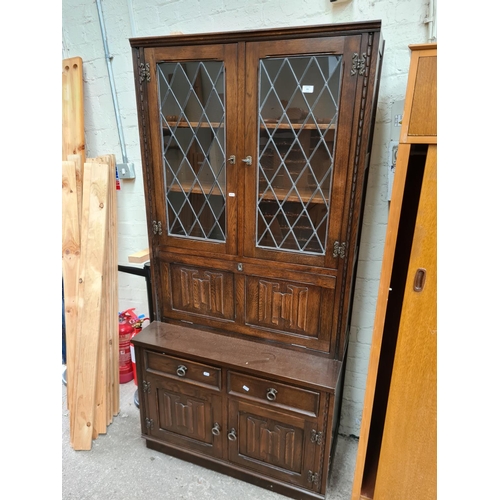 501 - A Jaycee oak bookcase cabinet with two upper glazed doors, fall front, two drawers and two cupboard ... 