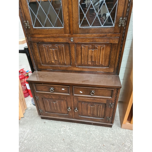 501 - A Jaycee oak bookcase cabinet with two upper glazed doors, fall front, two drawers and two cupboard ... 