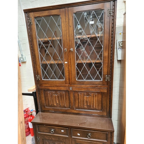 501 - A Jaycee oak bookcase cabinet with two upper glazed doors, fall front, two drawers and two cupboard ... 