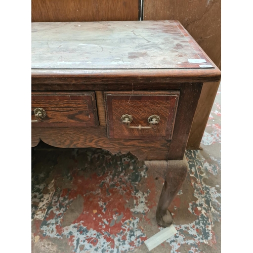 502 - An oak writing table on cabriole supports with three drawers - measuring approx. 77cm high, 91cm wid... 