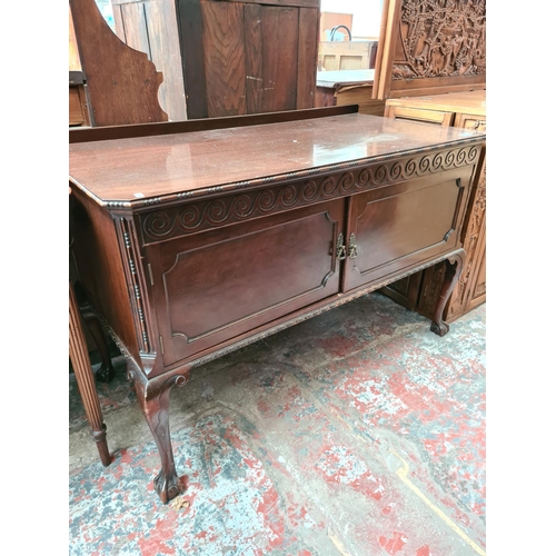 505 - A mahogany two door cabinet on ball and claw supports - measuring approx. 78cm high, 121cm wide and ... 