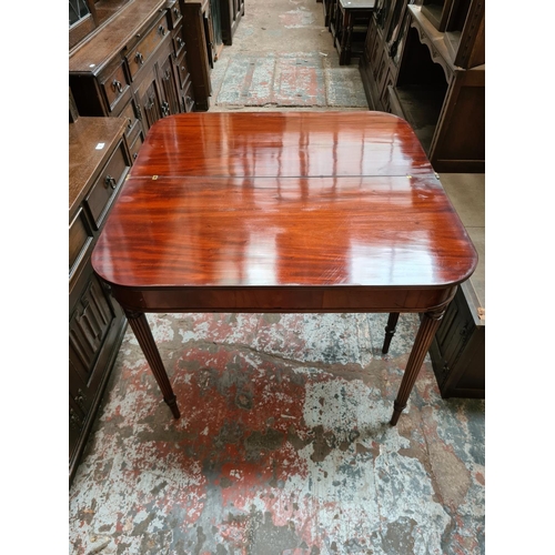 507 - A 19th century mahogany fold over tea table on tapering supports - measuring approx. 74.5cm high and... 