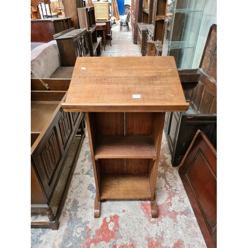 512 - A mid 20th century oak lectern with two lower shelves - measuring approx. 108cm high and 61cm wide