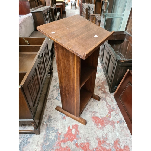 512 - A mid 20th century oak lectern with two lower shelves - measuring approx. 108cm high and 61cm wide