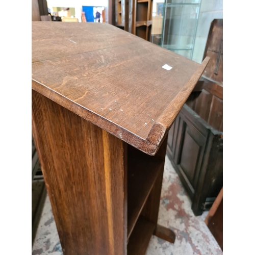 512 - A mid 20th century oak lectern with two lower shelves - measuring approx. 108cm high and 61cm wide