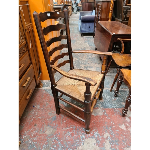 518 - A 19th century elm farmhouse ladder back armchair with rush seat and lower stretcher - measuring app... 