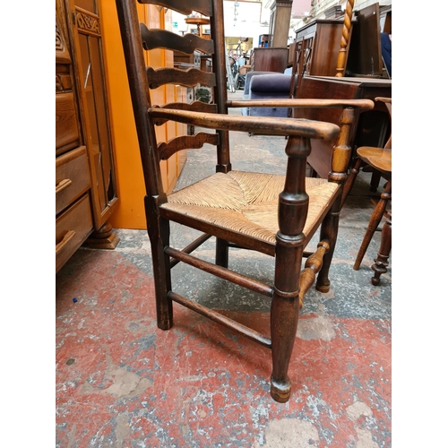 518 - A 19th century elm farmhouse ladder back armchair with rush seat and lower stretcher - measuring app... 