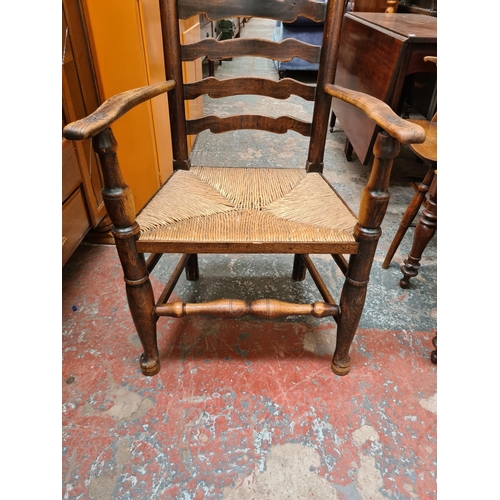 518 - A 19th century elm farmhouse ladder back armchair with rush seat and lower stretcher - measuring app... 