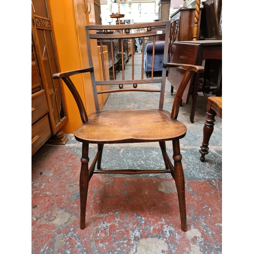 520 - An Arts and Crafts elm elbow chair - measuring approx. 83.5cm high, 52cm wide and 43cm height to sea... 