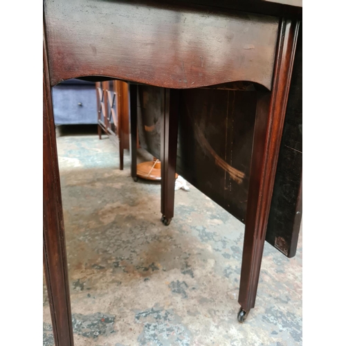 521 - A Georgian mahogany drop leaf gate legged dining table on eight tapered supports and later added cas... 