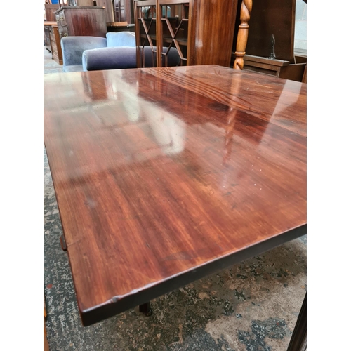 521 - A Georgian mahogany drop leaf gate legged dining table on eight tapered supports and later added cas... 