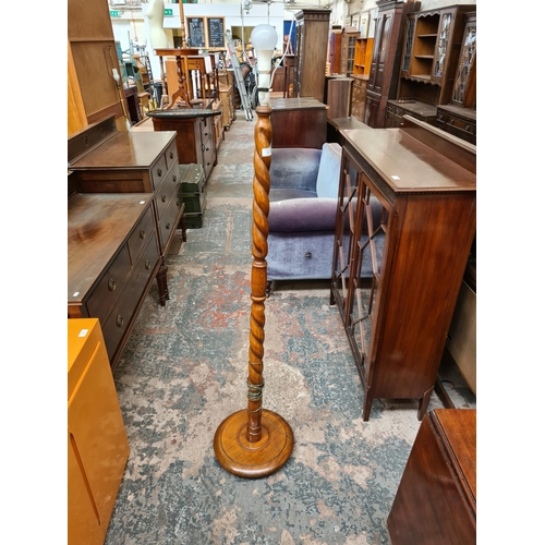 522 - An oak barley twist standard lamp - measuring approx. 142cm without bulb and holder