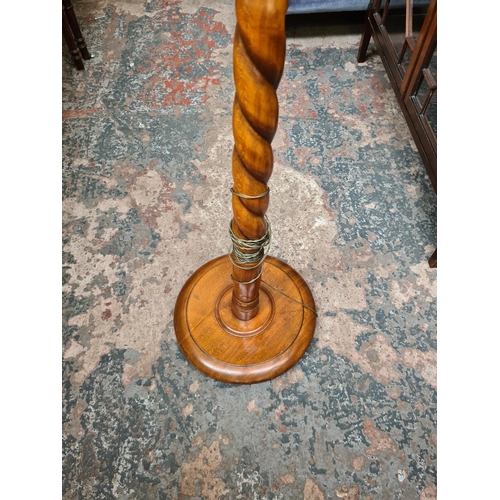 522 - An oak barley twist standard lamp - measuring approx. 142cm without bulb and holder