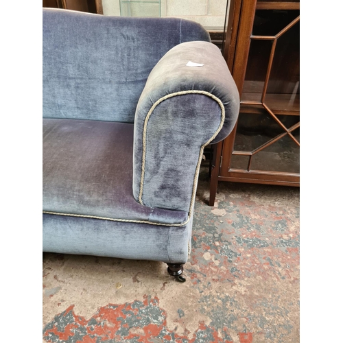 524 - A Victorian blue upholstered drop arm two seater sofa on castors - measuring approx. 163cm wide