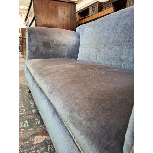 524 - A Victorian blue upholstered drop arm two seater sofa on castors - measuring approx. 163cm wide