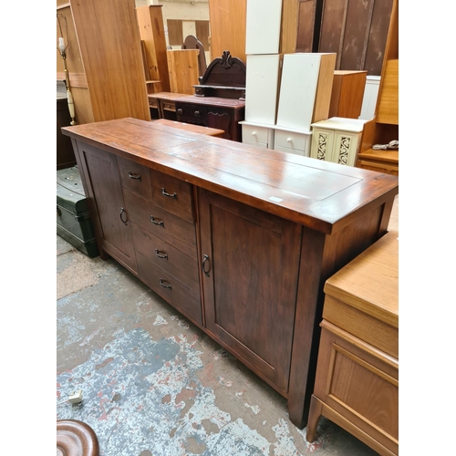 541 - A modern hardwood sideboard with five central drawers and two outer cupboard doors (measuring approx... 