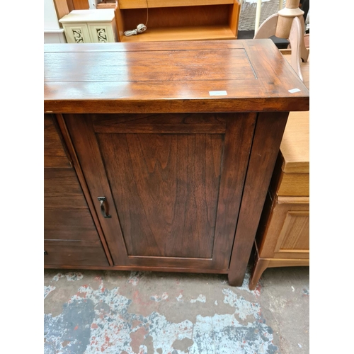 541 - A modern hardwood sideboard with five central drawers and two outer cupboard doors (measuring approx... 