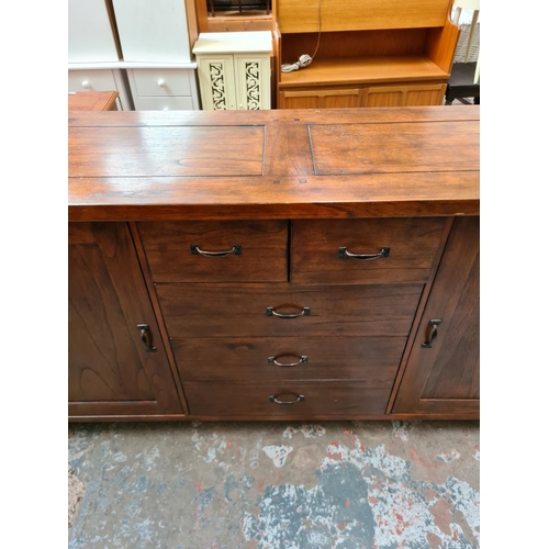 541 - A modern hardwood sideboard with five central drawers and two outer cupboard doors (measuring approx... 