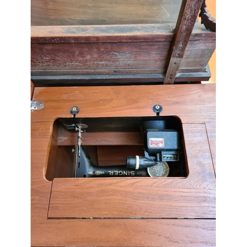 550 - A teak sewing table containing a vintage Singer sewing machine - Serial No. Y5818054