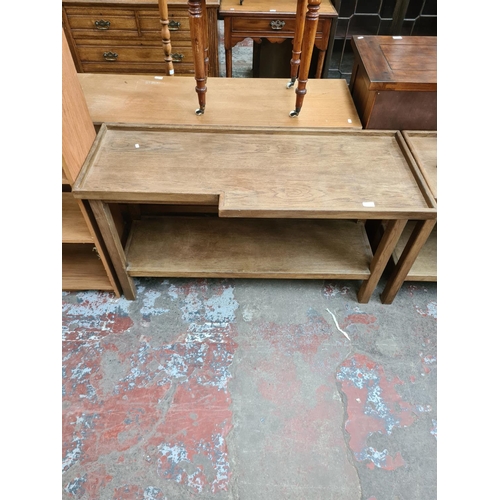 555 - An oak two tier console table - measuring approx. measuring approx. 125cm wide and 71cm high