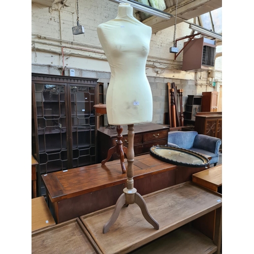 556 - A female shop mannequin torso on pedestal base - measuring approx. 146cm high