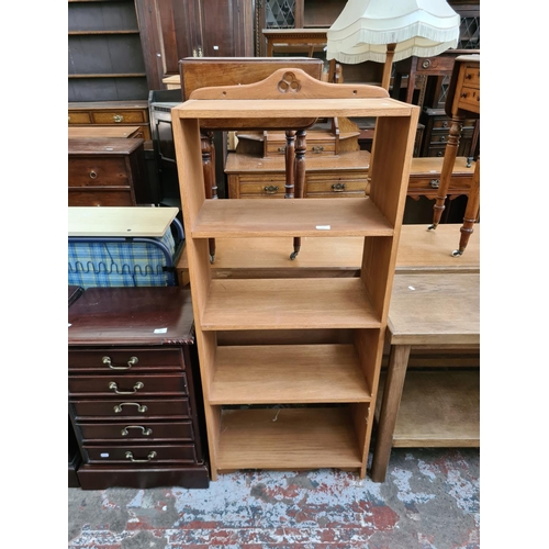 557 - An Arts and Crafts style oak four tier freestanding bookcase - measuring approx. 133cm high and 59cm... 