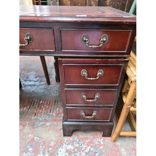 561 - A mahogany twin pedestal writing desk with eight outer drawers, one central drawer and red leather i... 